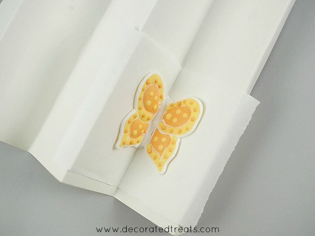 Assembled royal icing butterfly on a folded paper