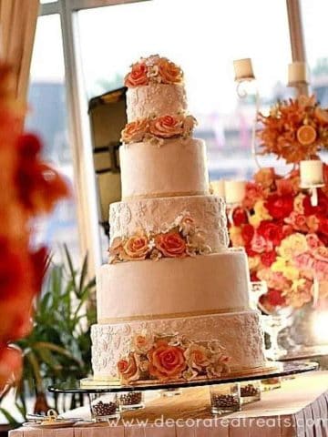A 5 tier wedding cake decorated in orange and yellow.