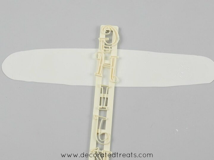 Tappit letter cutter on a long piece of gum paste strip