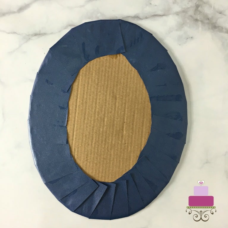 A brown cake board wrapped in blue paper