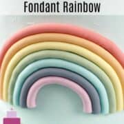 A fondant rainbow in 7 colors on the side of a round cake.
