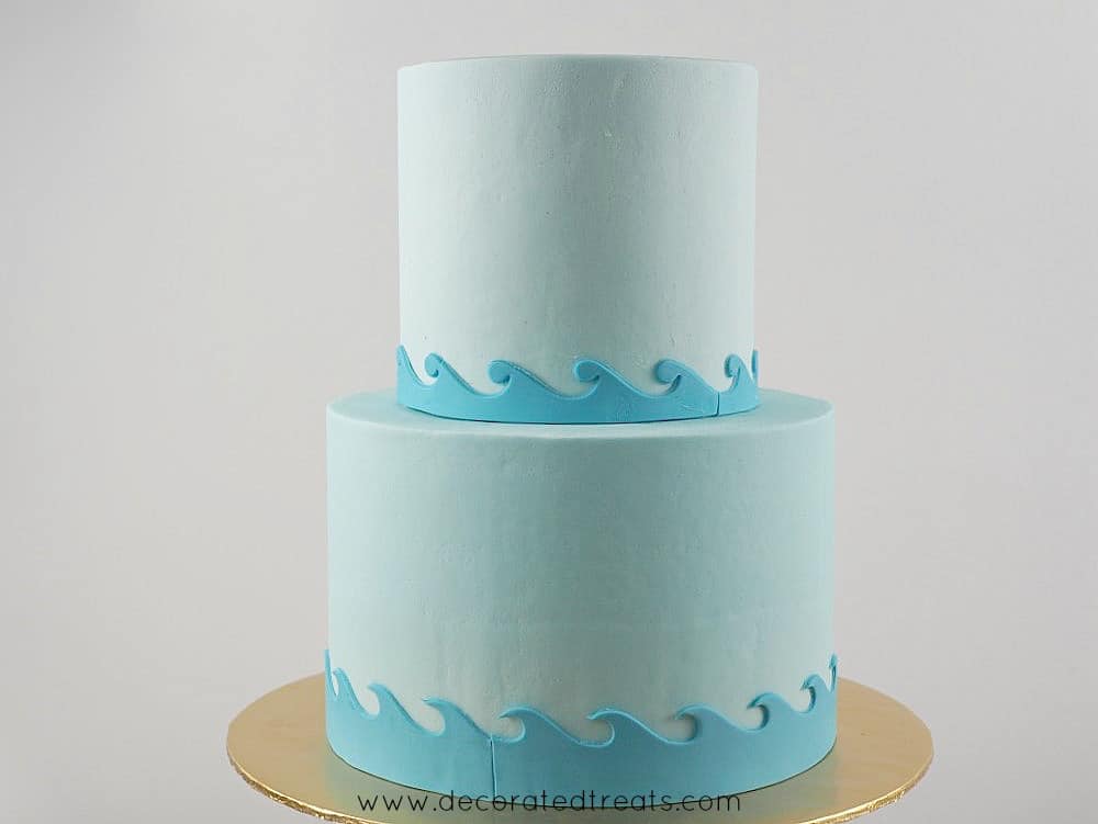 2 tier round cake in light blue fondant and wavy fondant borders