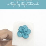 A poster showing blue buttercream flower on a parchment paper square.