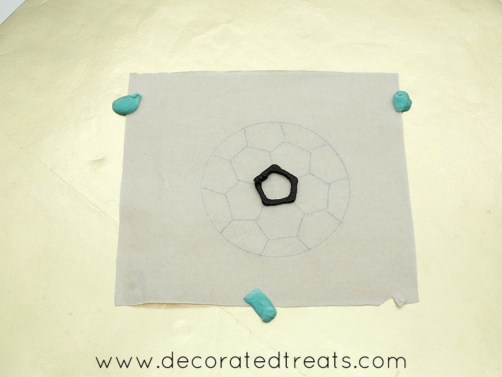 Black outline piping on a soccer ball parchment template