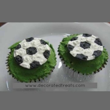 2 cupcakes with soccer ball toppers