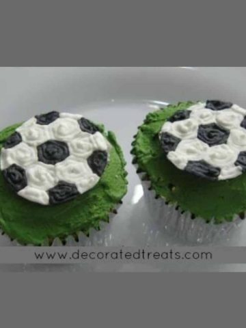 2 cupcakes with soccer ball toppers.