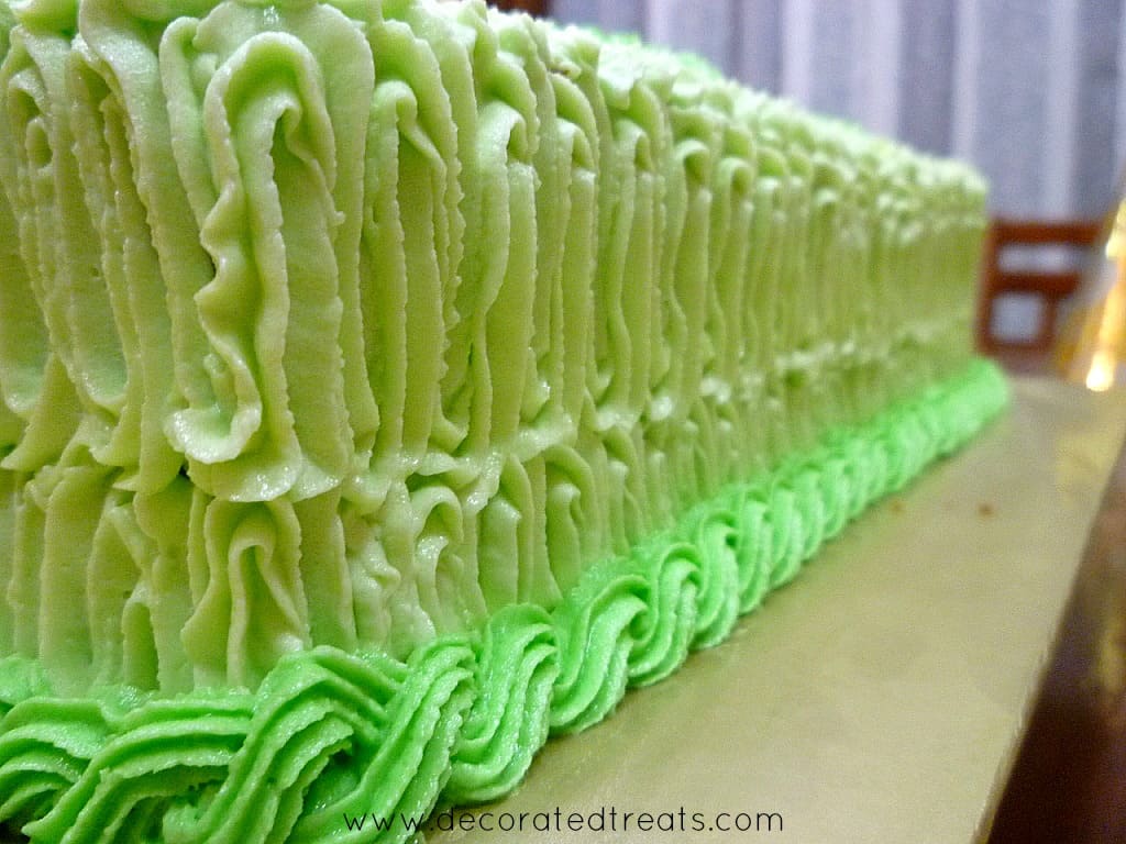 Green buttercream zigzag piping and rope border