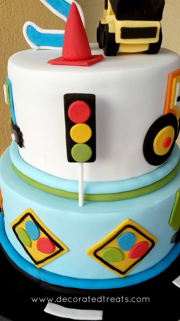 A traffic light made of fondant on the side of a 2 tier cake
