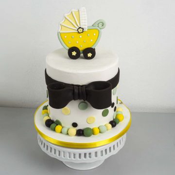 A round cake with a yellow buggy cake topper