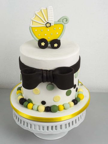 A round cake with a yellow buggy cake. topper