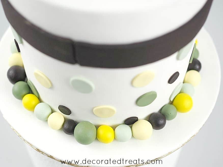 Baby shower cake border made using round fondant balls in yellow, green and brown