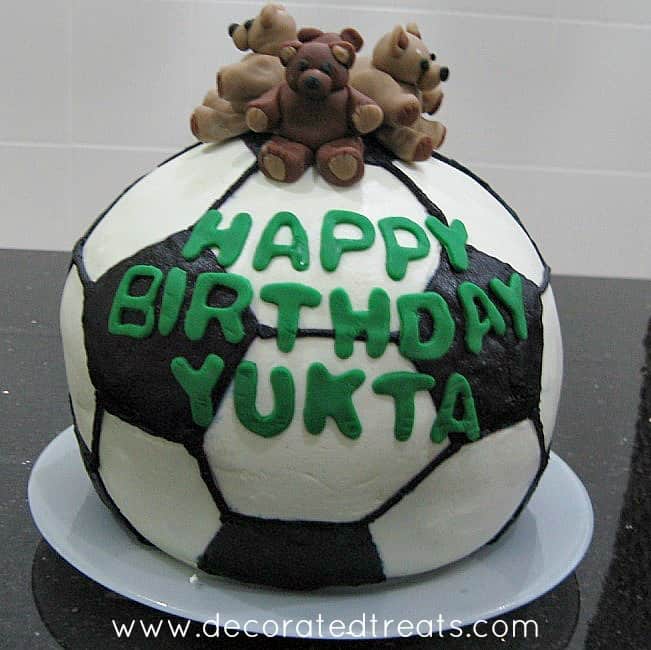 3D ball cake in black and white with 4 fondant teddies as the toppers