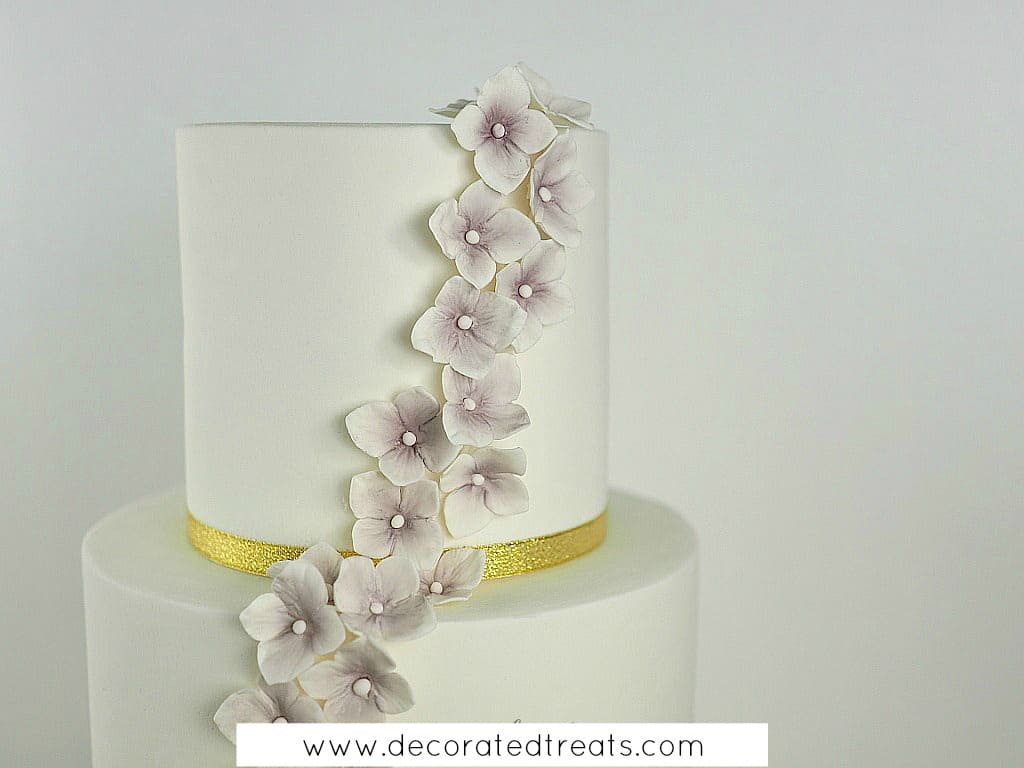 Gum paste hydrangeas in purple on a white cake