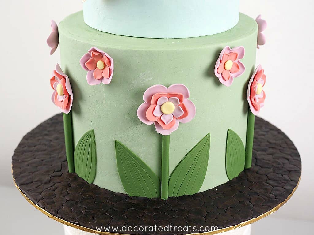 Fondant flowers on the bottom tier of a cake