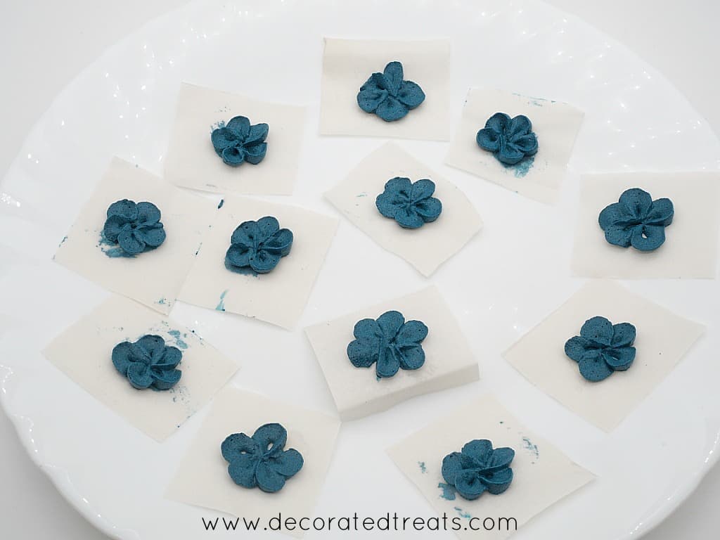 Blue buttercream flowers on parchment squares