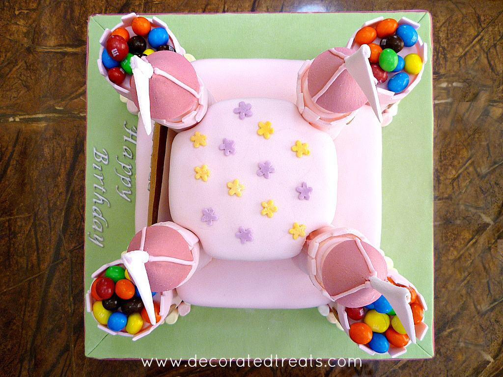 The top of a 2 tier pink castle cake decorated with M&Ms and marshmallows