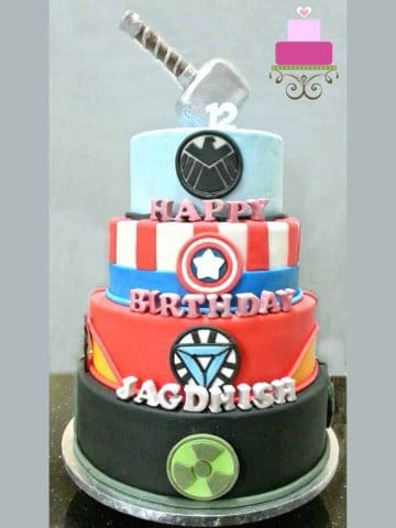 A 4-tier Marvel Superhero birthday cake with Thor hammer topper.