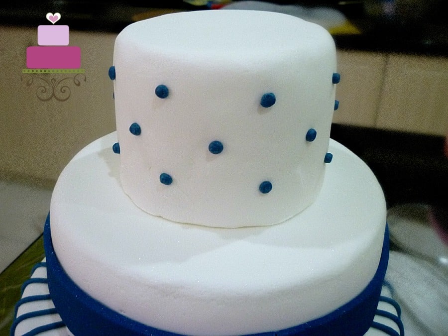 Blue polka dots on a white round cake