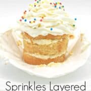 A cupcake with its casing peeled off, and topped with buttercream and sprinkles