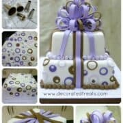 A two tier gift box cake decorated in brown and purple circle cut outs and pretty loop bow