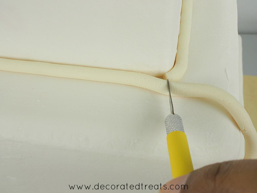 Cutting excess fondant with a sugar craft knife