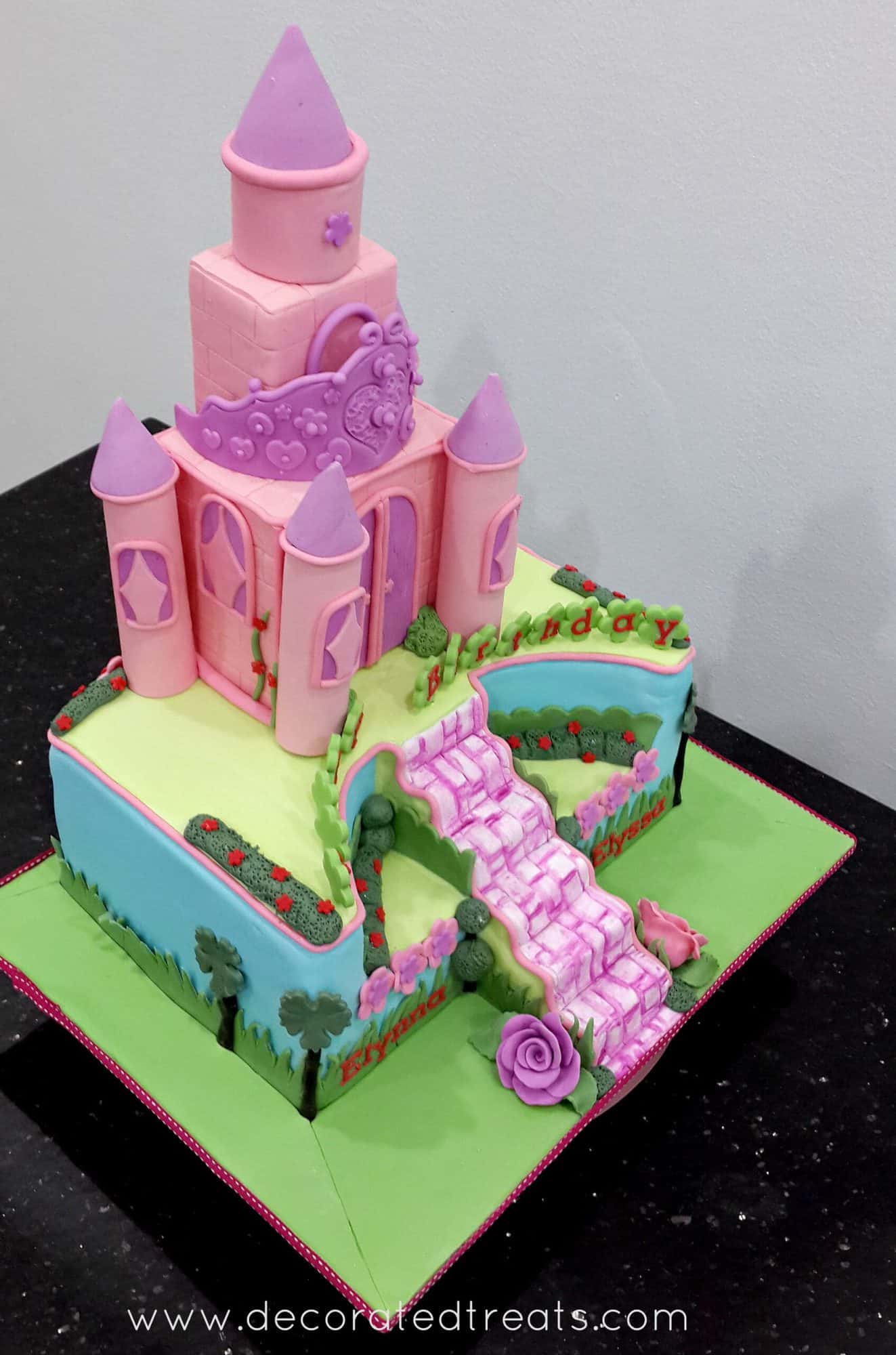 A rectangle cake with a pink castle cake topper.