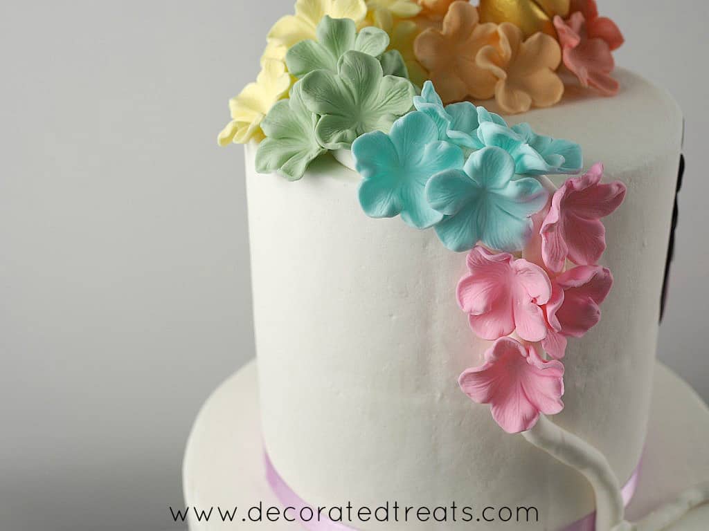 Red, orange, yellow, green, blue and pink lowers on a unicorn cake