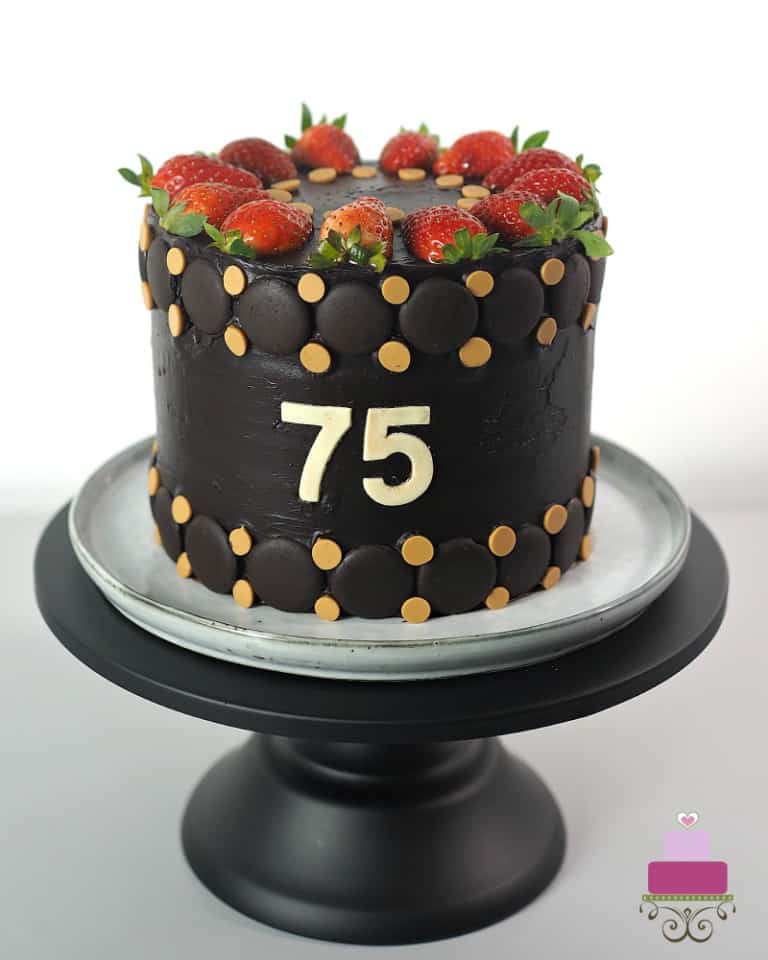 A 75th birthday cake in chocolate ganache decorated with fresh strawberries and butterscotch chips