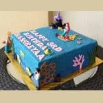 A square blue cake decorated with Ariel the Little Mermaid characters.