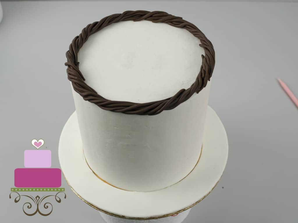 Fondant twigs garland on a white cake