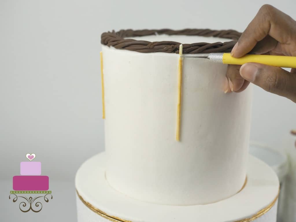 Using a needle tool to mark a cake