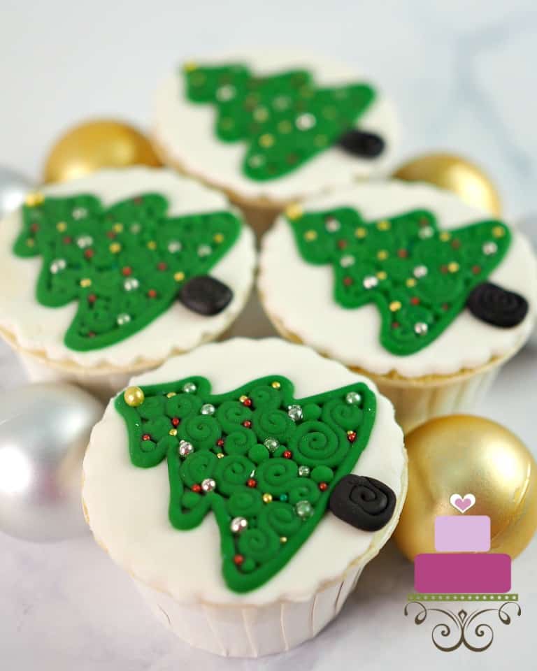 4 cupcakes with 2d mini Christmas tree decoration.