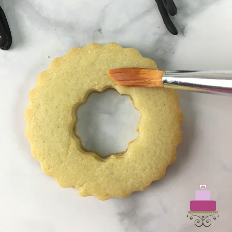 Brushing a ring wreath cookie.