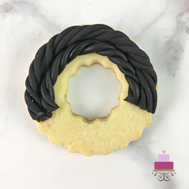 Wreath cookie decorated with twisted fondant strips.