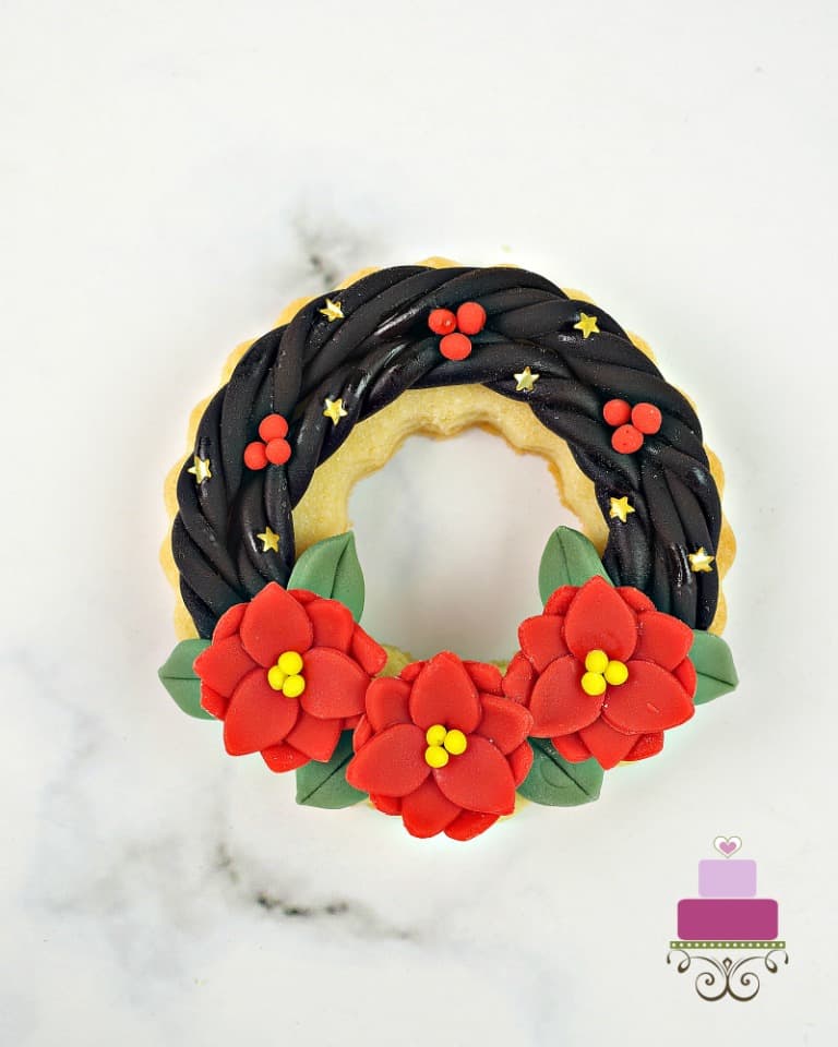 Cookies decorated to look like poinsettia wreaths.
