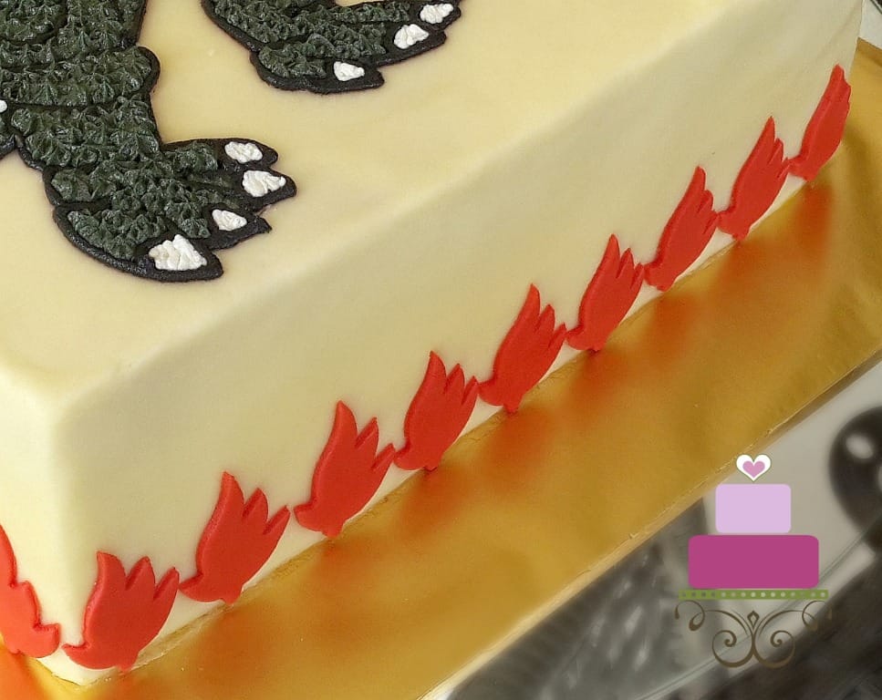Red fondant flame design on the sides of a cake