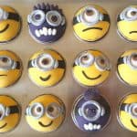 Minion cupcakes decorated with various yellow and purple minion faces.