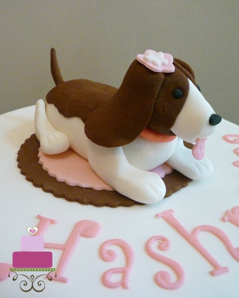 A fondant dog topper on a round cake