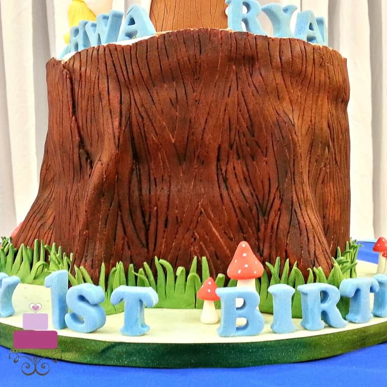 A round cake decorated like a tree stump