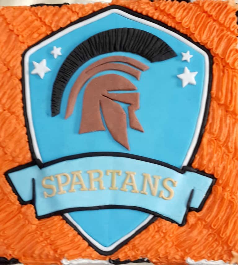 Spartans logo on an orange buttercream cake