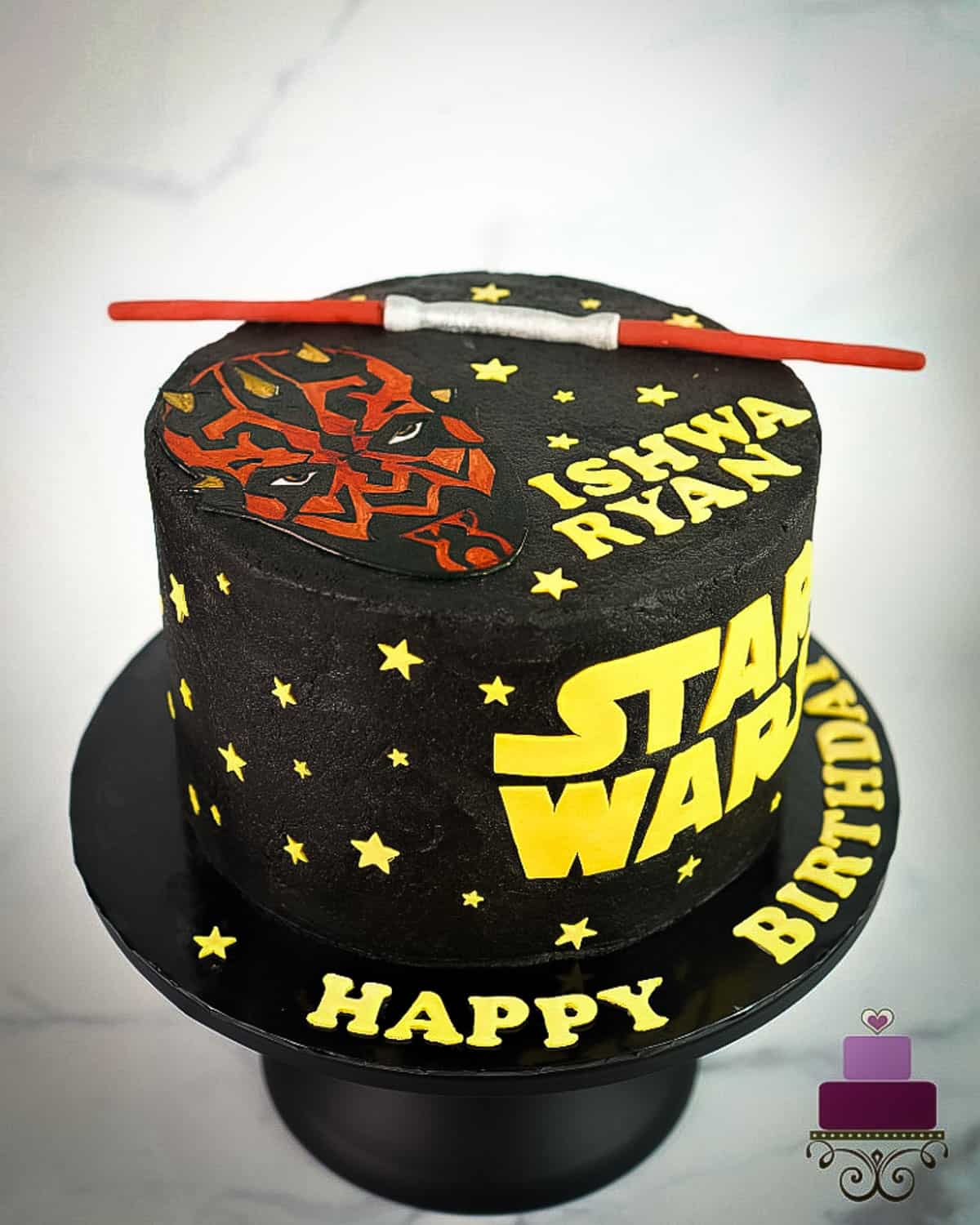 A round black cake with Star  Wars themed cake.