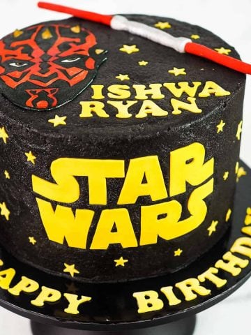 A round black cake with Star Wars themed cake.