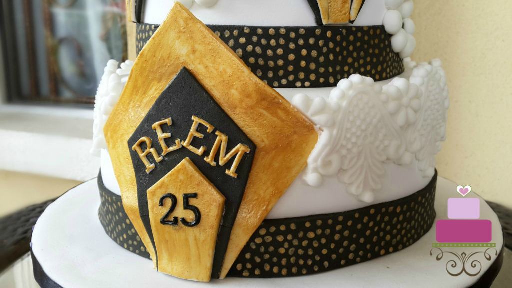 Black and gold fondant plaque on a cake