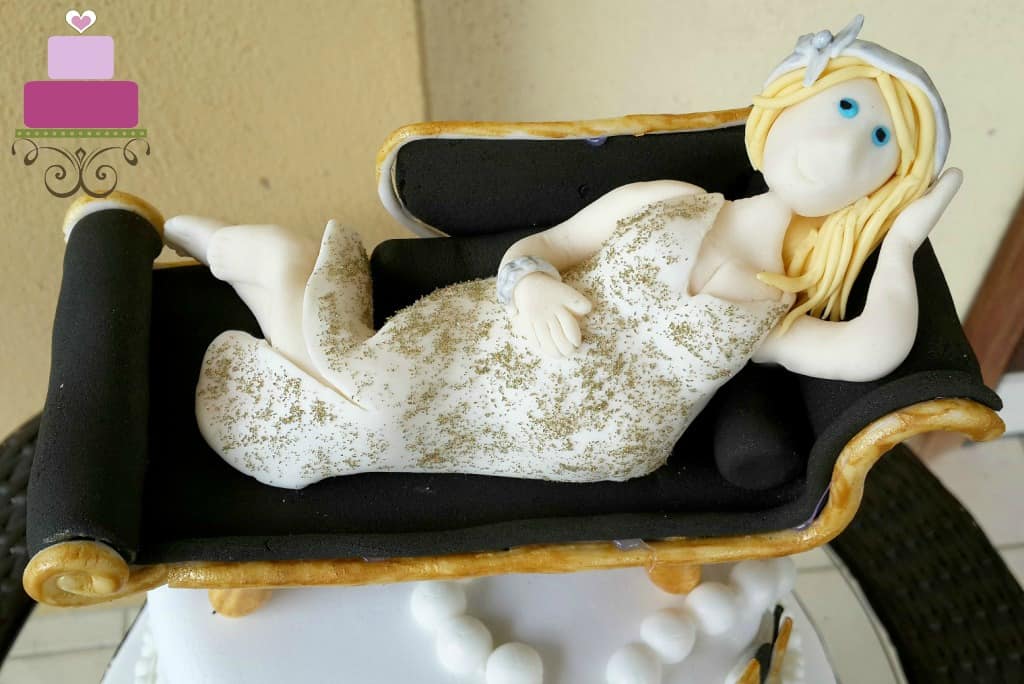 A lady lying on a couch cake topper