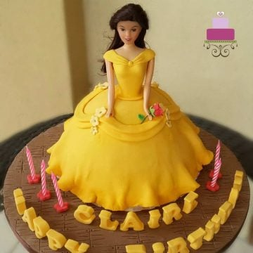 A doll cake decorated in yellow gown and a stalk of rose like Belle from Beauty and the Beast
