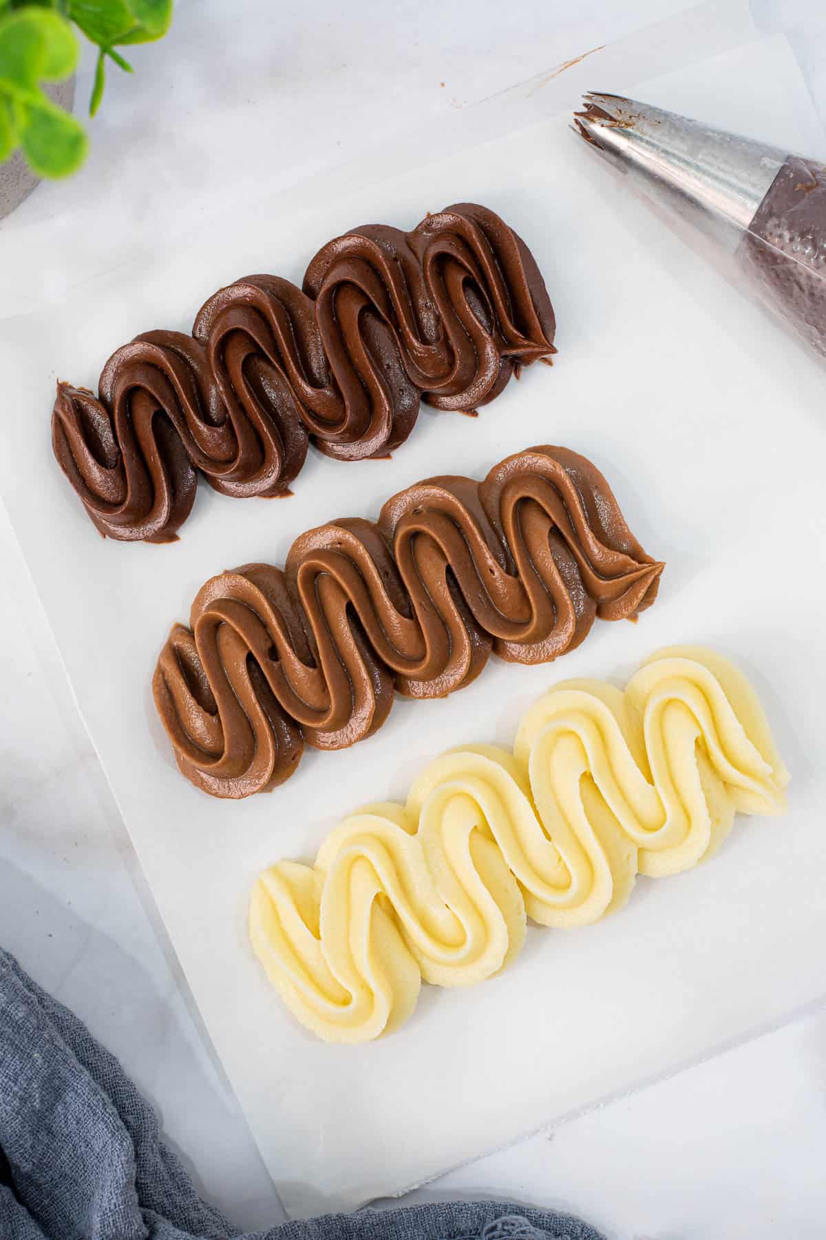 Three rows of zig zag piped ganache icing in dark chocolate, milk chocolate and white chocolate.