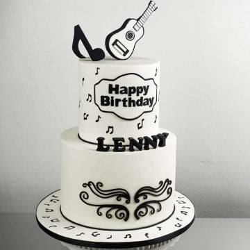 A black and white 2 tier cake with guitar topper and black music note topper