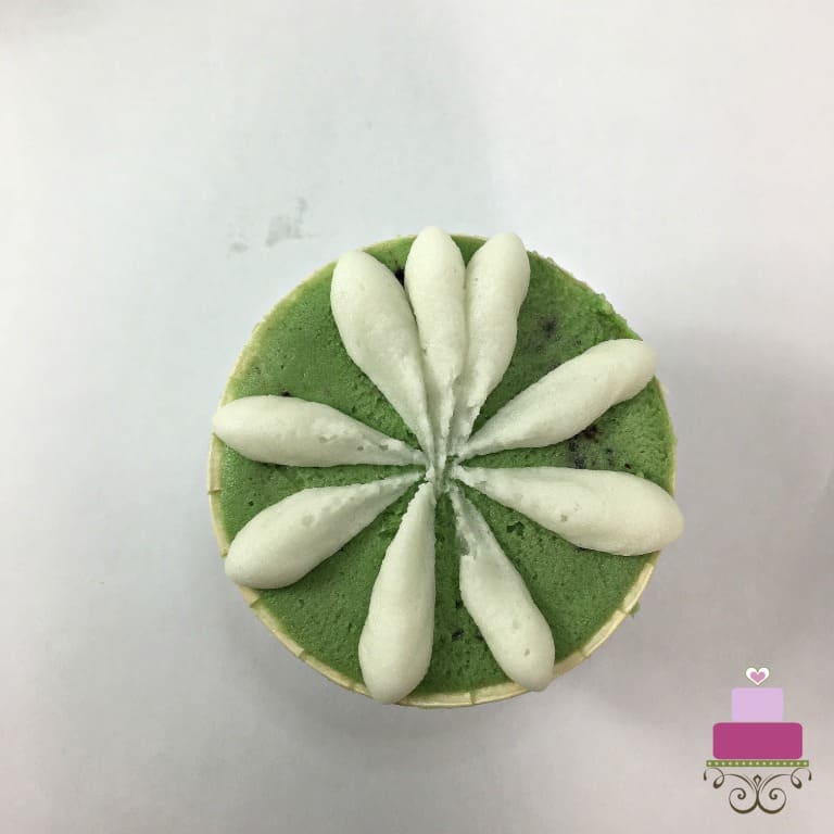 White petals on a green buttercream covered cupcake
