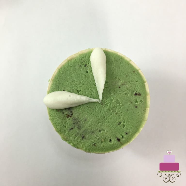 2 white petals on a green buttercream covered cupcake