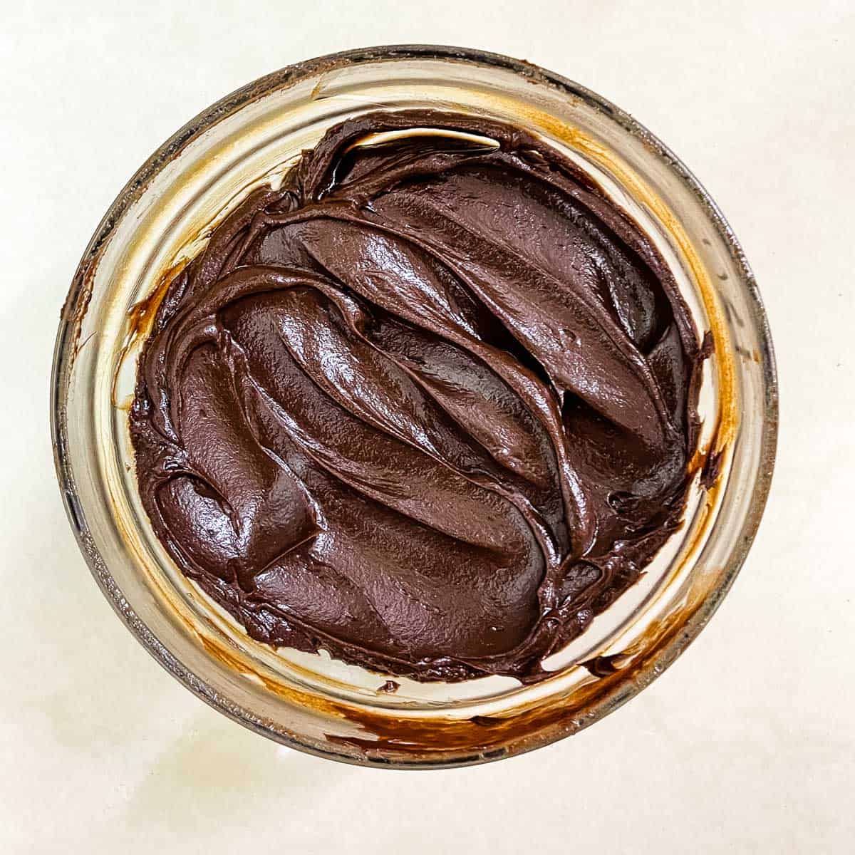 A bowl of dark chocolate ganache in spreadable consistency.
